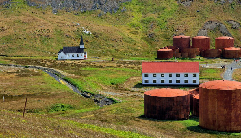 Grytviken Landing Site on South Georgia with a church, rusted tanks, and buildings from the historic whaling station